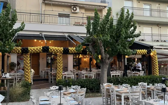 Kali Kardia tou Nikola taverna in Rafina, with outdoor tables under the trees