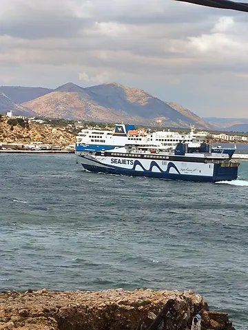 A Seajets ferry leaving Rafina port under a cloudy sky
